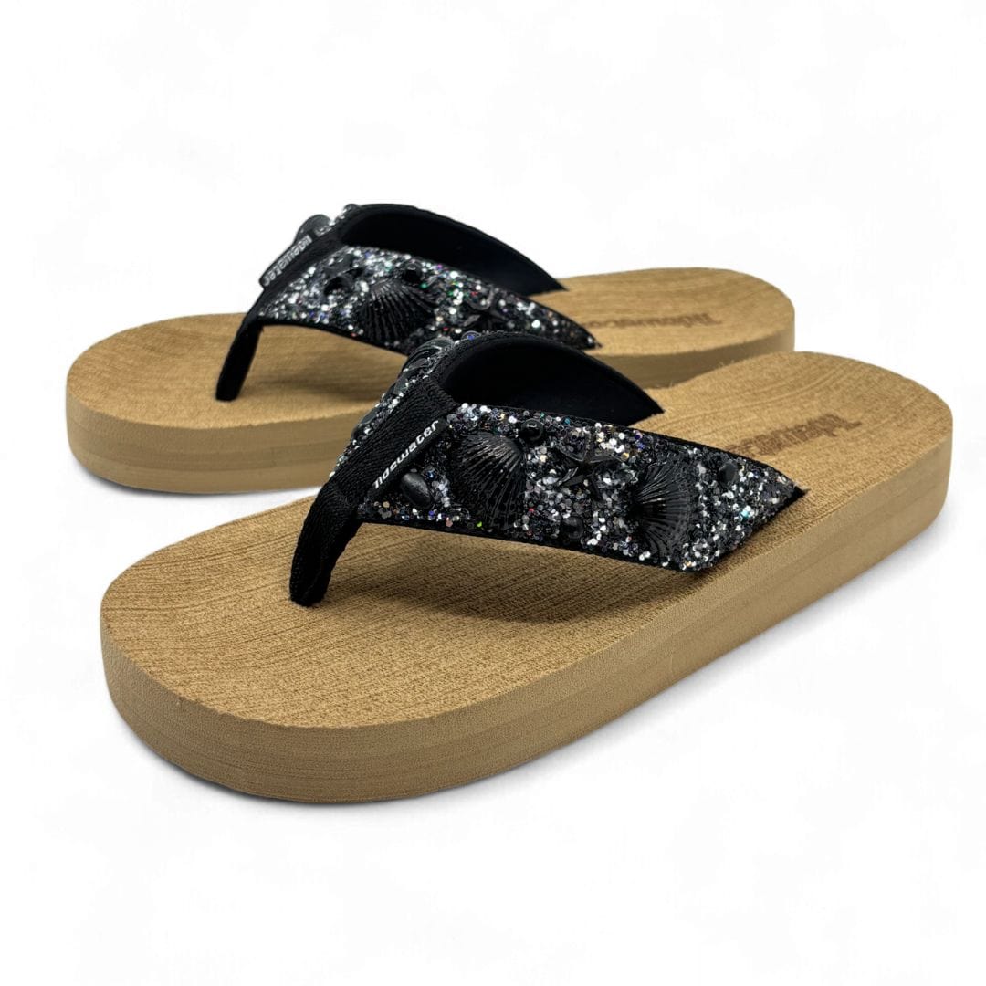 Pair of sandals with wooden sole and black glittery straps on a white background