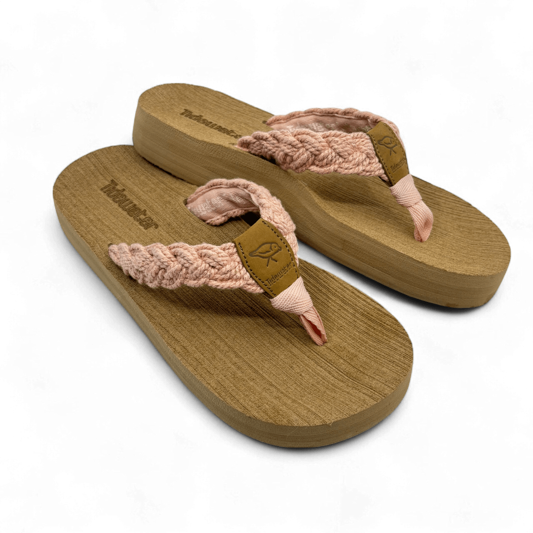 Pair of flip flops with tan comfort footbed and blush-pink braided straps featuring soft shimmer and leather accent tag