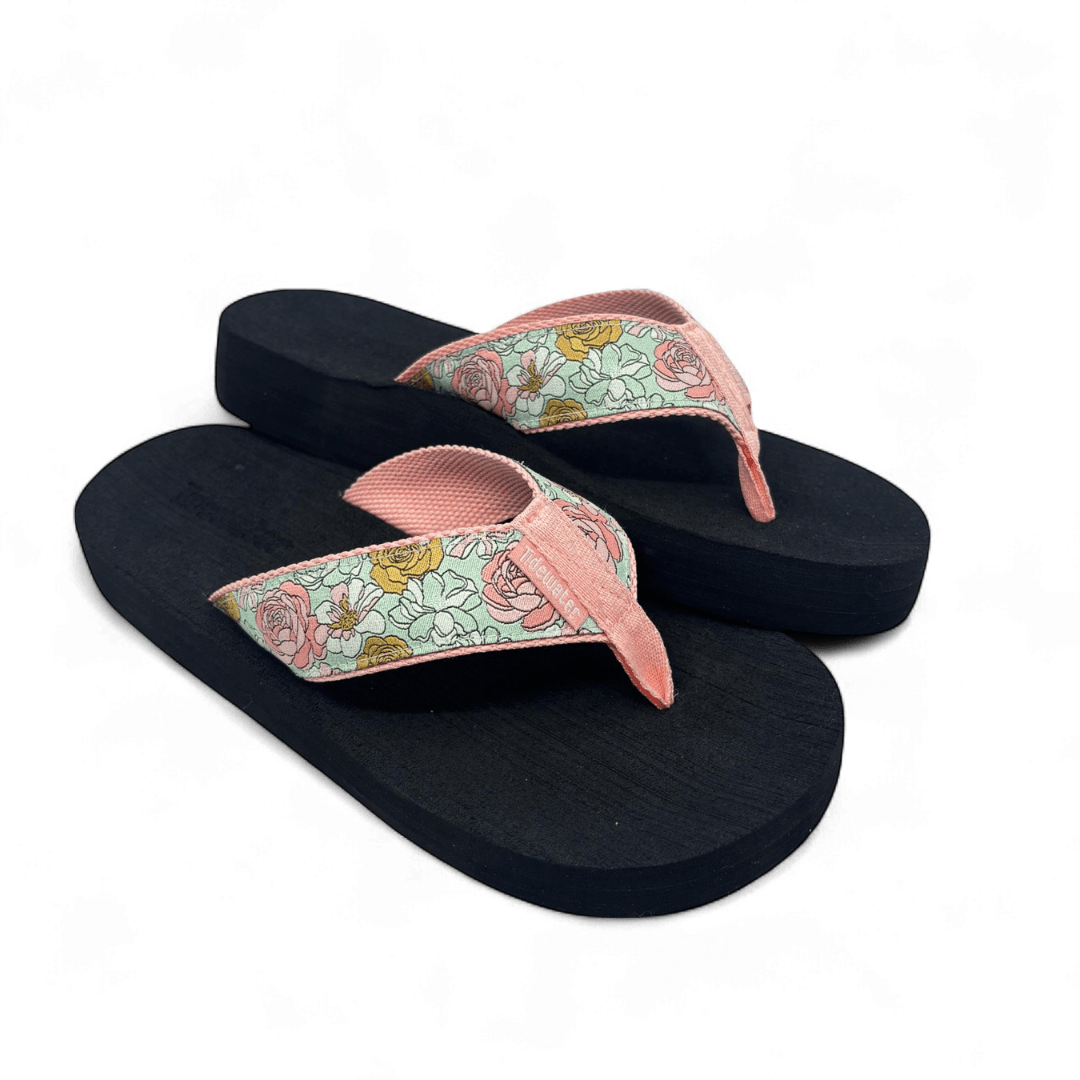 Pair of flip flops with black footbed and pink straps featuring mint, blush, and yellow floral pattern with soft inner lining