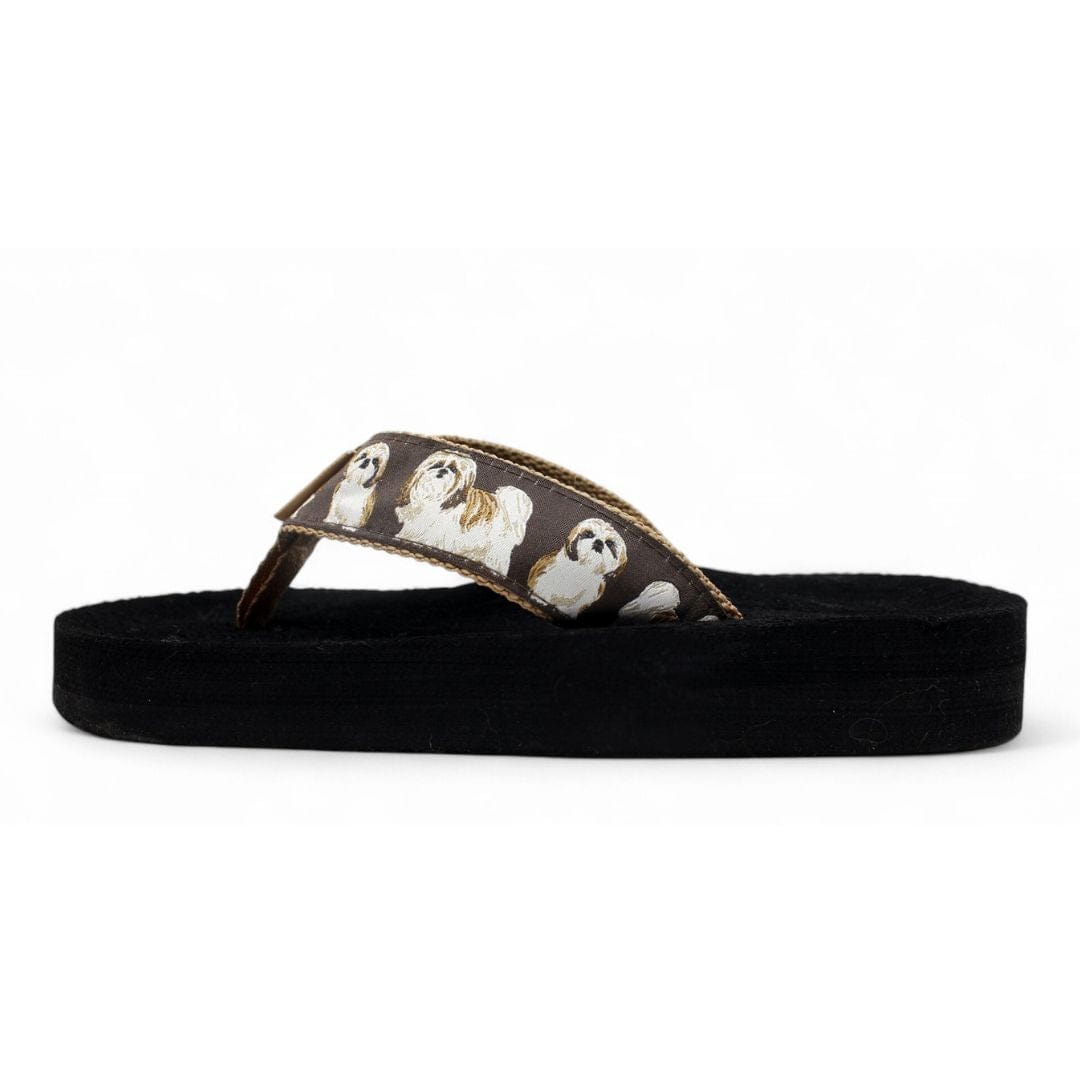 Black flip-flop featuring a brown strap adorned with Shih Tzu dog illustrations, perfect for casual summer wear.