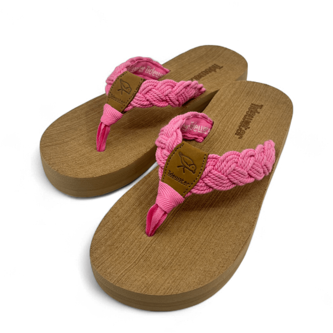 Pair of flip flops with tan comfort footbed and braided bubblegum pink straps with leather accent and soft toe post

