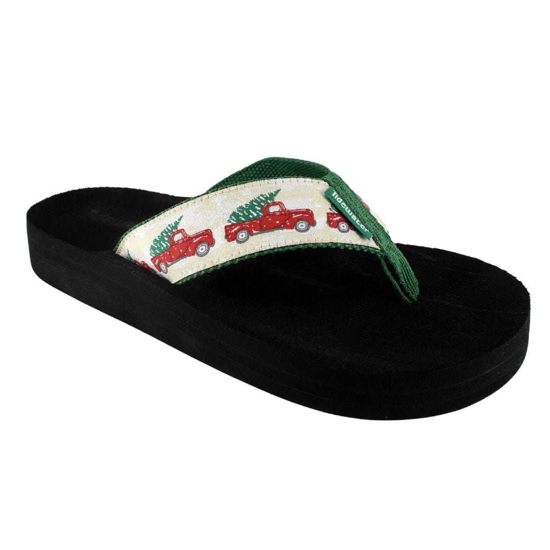 Cozy flip-flop featuring a festive design of red trucks carrying Christmas trees on a soft black sole.
