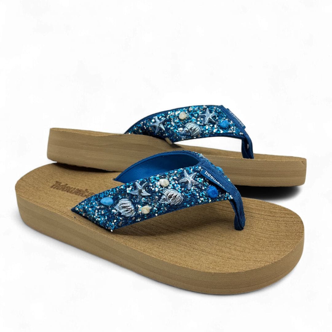 Pair of sandals with blue embellishments on a white background