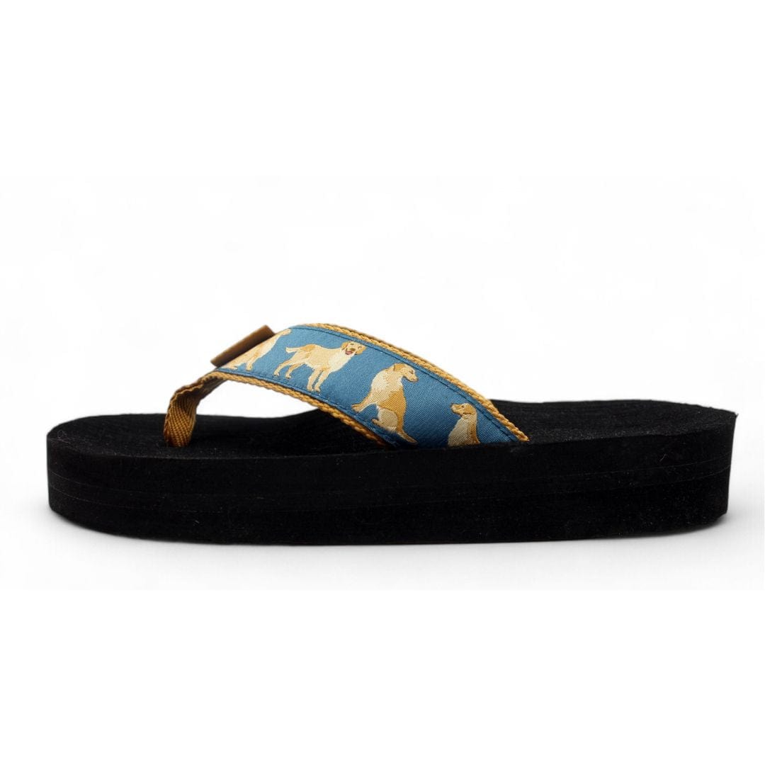 Blue flip-flop featuring a playful golden retriever pattern on the strap, set on a black sole.
