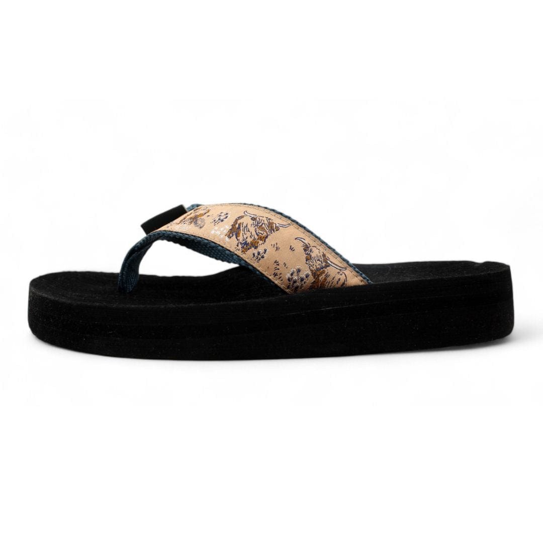Highland Cow flip-flops featuring a unique design on the strap and a comfortable black sole for casual wear.