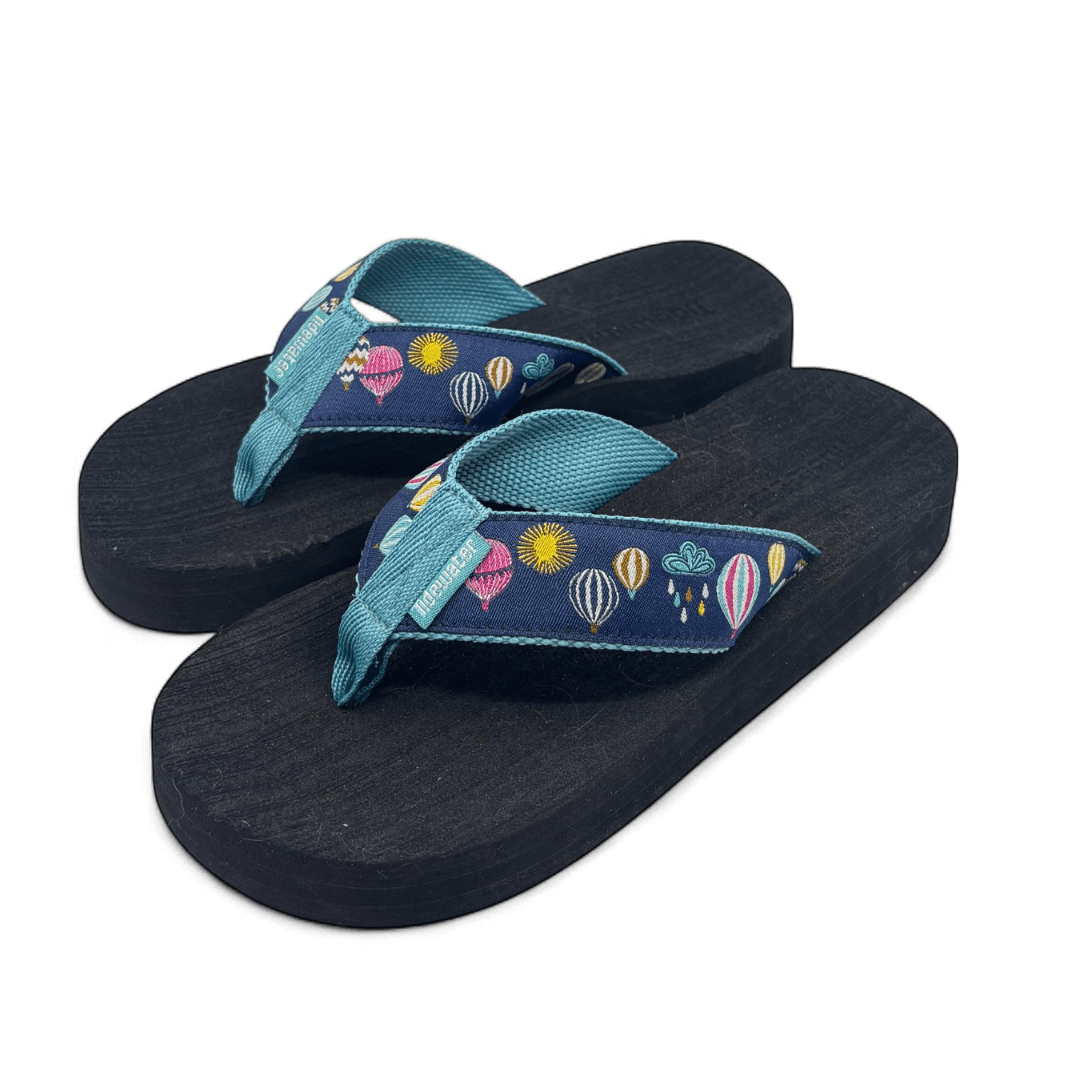 Pair of flip flops with black footbed and navy straps featuring colorful embroidered hot air balloons and teal inner lining