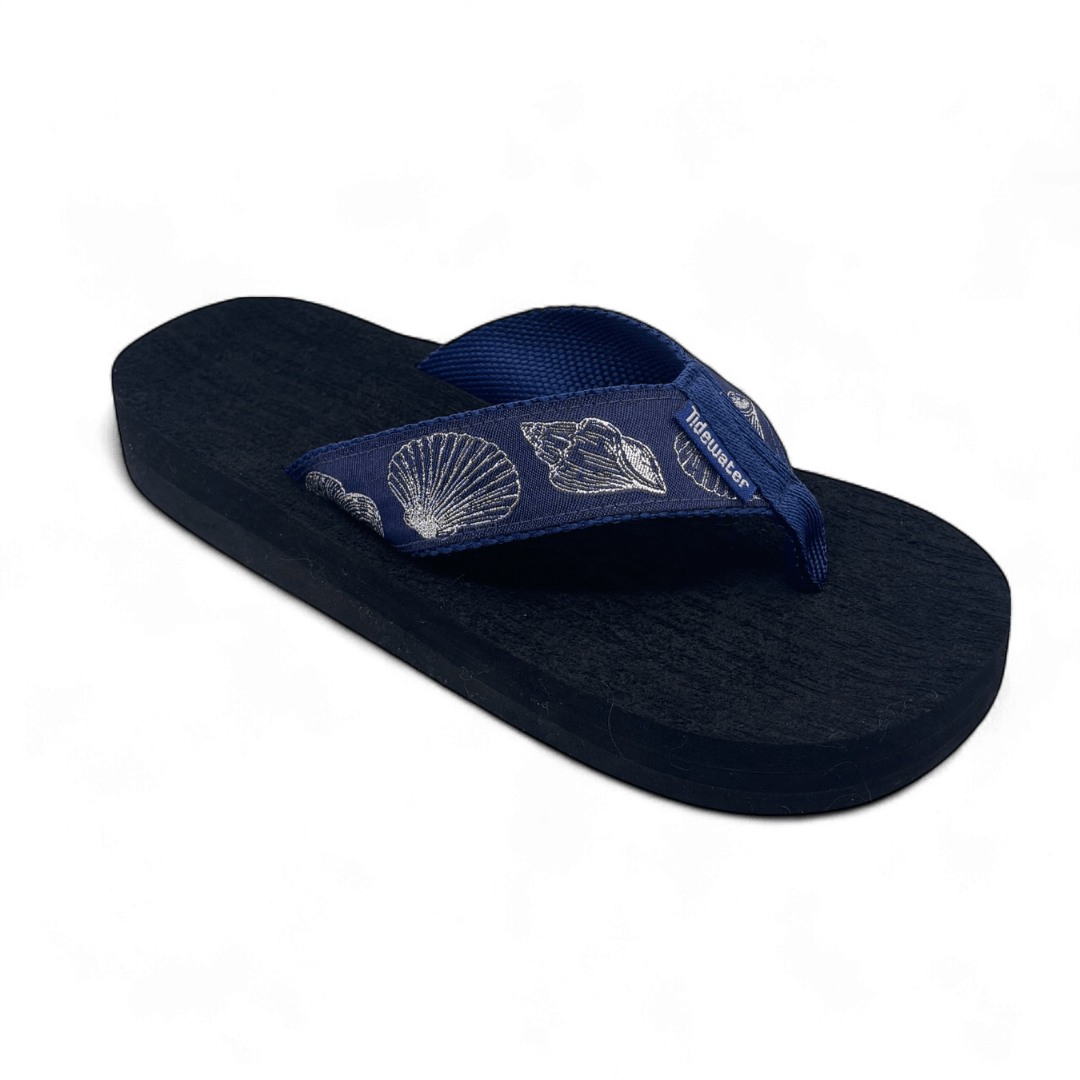 Navy flip flop with soft navy straps and embroidered silver seashells, designed with contoured black comfort footbed