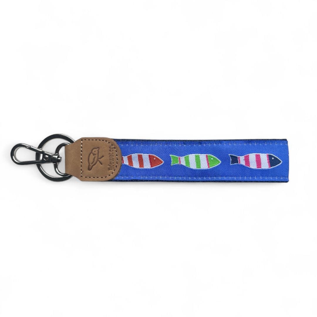 Colorful keychain featuring a blue strap with striped fish designs and a brown leather accent. Perfect for adding a fun touch to your keys.