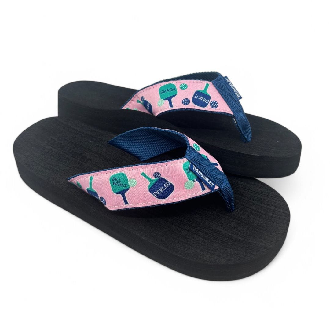 Fun pickleball-themed flip-flops with a pink strap featuring paddle graphics, perfect for casual summer wear.